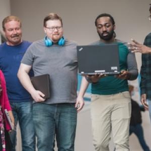 Five HARMAN employees holding laptops.