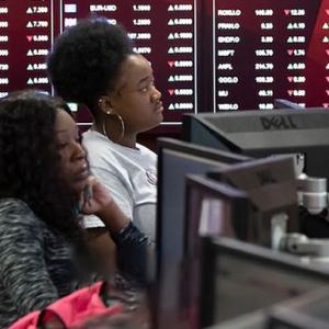 Female people of color sit in a classroom behind computer screens.
