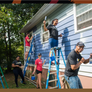 Children and Home Depot volunteers at one of the homes that are being refurbished. 