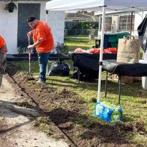 This is how doers serve. Team Depot volunteers are working on the front of a house and performing landscaping.