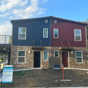 Blue shipping container house on left, burgundy shipping container house on right