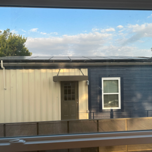 Solar panels seen on the roof of a house through a window 