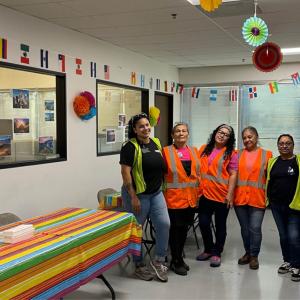 group of people wearing high-vis vests in a decorated break room