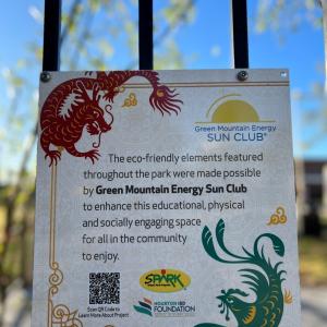 White sign on black fence featuring red and green dragons