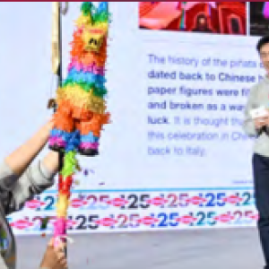A person swinging at a pinata while others look on.
