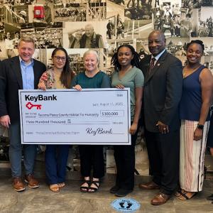 Representatives from KeyBank and Habitat for Humanity shown with a $300,000 grant check.