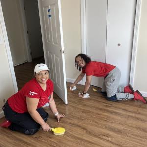 KeyBank volunteers cleaning a floor inside of a newly built home.