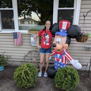 Valerie, shown with Mickey Mouse, in front of her refurbished home.