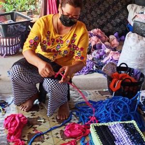 Thai woman weaving yarn.