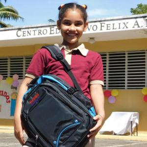Young student in front of a school in Latin America.