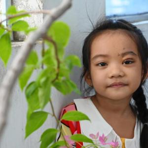 Han smiling, leaning against a wall.