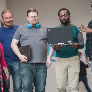 HARMAN employees viewing a laptop.