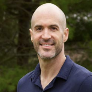 Headshot of a person stood in front of a tree