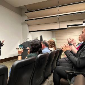 Moratz (left) teaching the sign for basketball during an ASL class at the DICK’S Sporting Goods Customer Support Center
