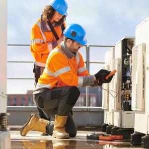 2 people working on a heat pump