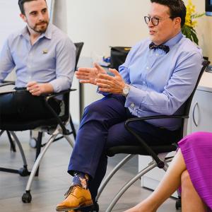 Henry Artalejo sat on a chair talking to other people