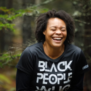 person laughing in front of tree