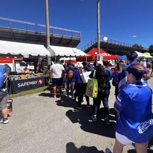 Photo of Safeway booth outside and a line of people in front of it.