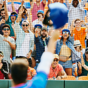 Fans at a baseball game cheering for a player.