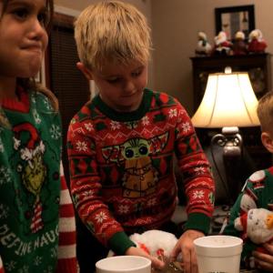 Children shown at a dinner table and dressed for the holiday.