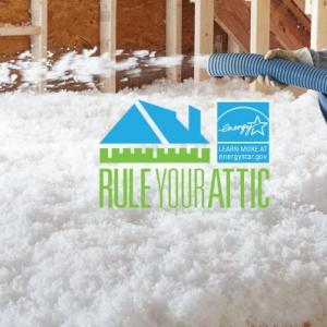 Worker installing insulation in an attic.
