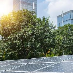 Solar panels shown against rising sun.