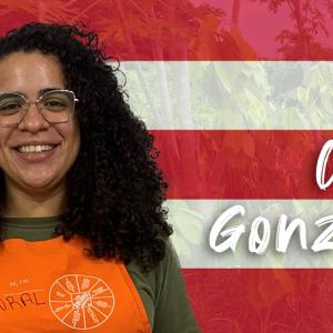 Coral Gonzalez shown in front of the flag of Puerto Rico.