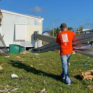 Home Depot volunteer shown cleaning up after Hurricane Ian.