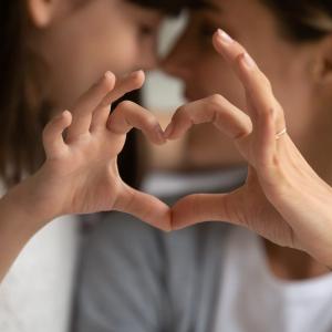 Parent and child making heart shape with hands