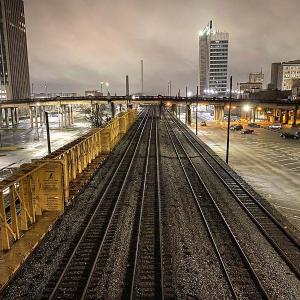 Dark and cloudy city landscape at night with railroad tracks in Indianapolis.