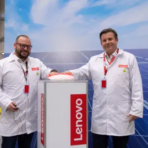 Two people stood in front of a Lenovo banner 