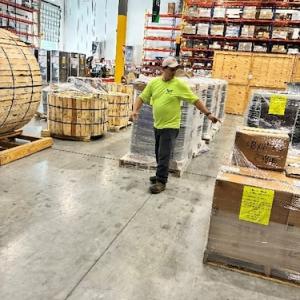 Worker in a Wesco warehouse preparing supplies for Hurricane Melissa relief.