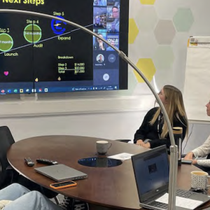 People sat around a desk looking at a presentation