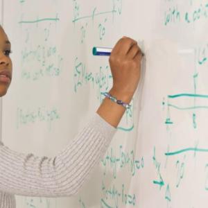 woman writing on a whiteboard