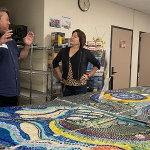 Man and woman talking in front of mosaic tiles
