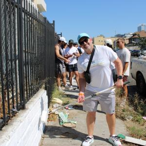 AEG volunteer painting over graffiti white white paint in Koreatown