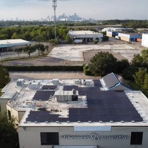 Solar panels on the roof of a building with the Houston skyline in the background