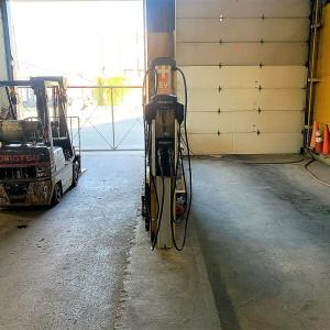 EV charger hanging in a warehouse with one garage door open behind it