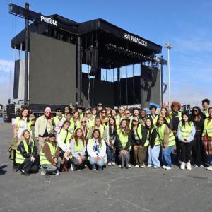 Students posed for a photo in front of the festival's main stage while on their exclusive festival grounds tour.