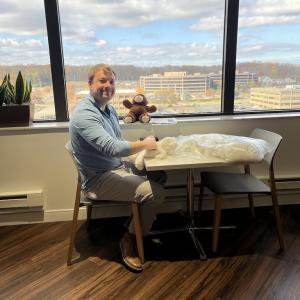 Covia employee poses with teddy bear for charities and hospitals