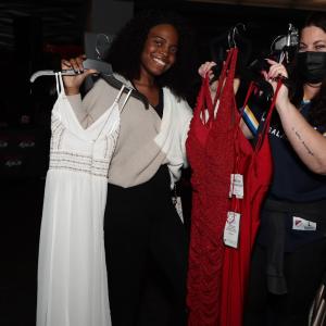 people holding up prom dresses