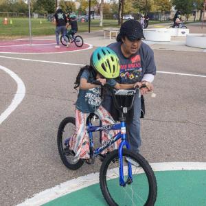 A young girl practiced riding a bike with the help of an AEG employee volunteer. (Photo: Jon Angel)