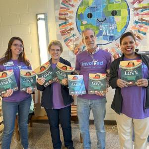 Four Short Hills volunteers holding up books