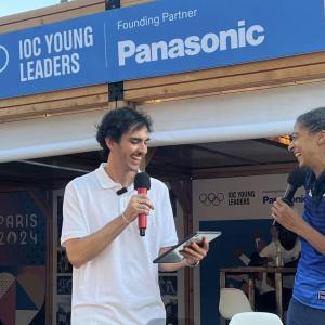 Two people stood opposite each other talking in to microphones 