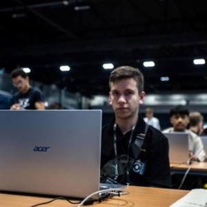 A participant with Acer laptop at IOI 2023
