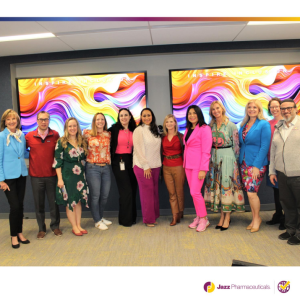 A group of people posed in front of multi-color displays 