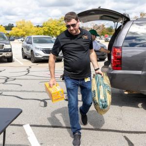 a person unloading supplies from the back of a car