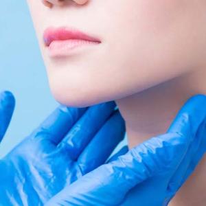 Japanese woman having a test done on her neck. Hands showing how a nasopharyngeal carcinoma is detected. 