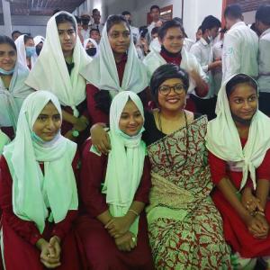Students shown with their teacher at a presentation.
