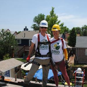 Workers installing solar panels on a roof.
